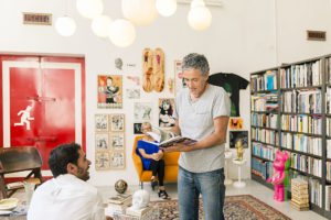 Paolo showing a book with his works in the living room of Cinema Flora Photographer Maria Teresa Furnari