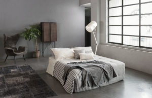 Bedroom with white sheets and grey blanket of Diesel Home Linen Collection Photographer Maria Teresa Furnari