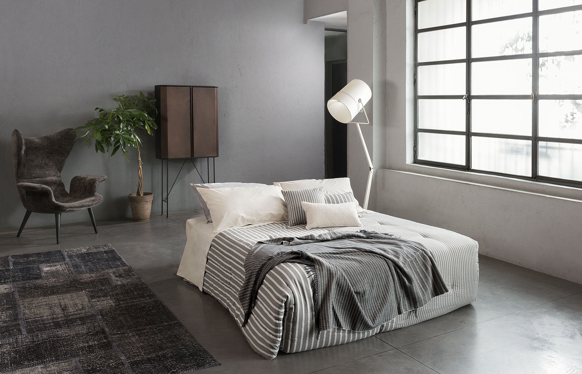 Bedroom with white sheets and grey blanket of Diesel Home Linen Collection Photographer Maria Teresa Furnari