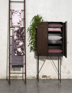 A cupboard with some pillows inside and a stair with pink towels of Diesel Home Linen Collection Photographer Maria Teresa Furnari