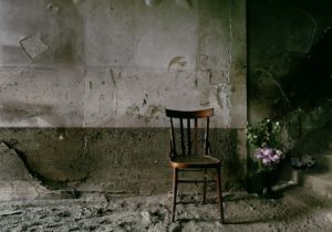 A chair without a leg and some flowers one of the trail of Giampilieri after the flood Photographer Maria Teresa Furnari